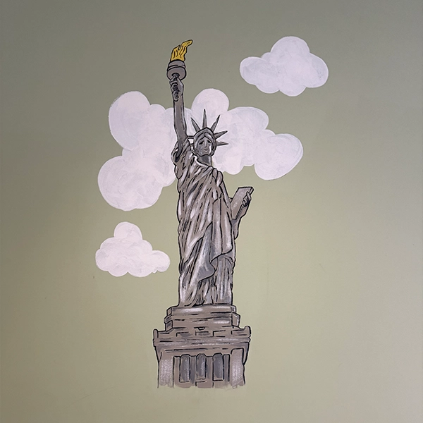 A mural of the Statue of Liberty, holding a torch high, surrounded by fluffy clouds against a green wall backdrop. A mural of the Statue of Liberty, holding a torch high, surrounded by fluffy clouds against a green wall backdrop.